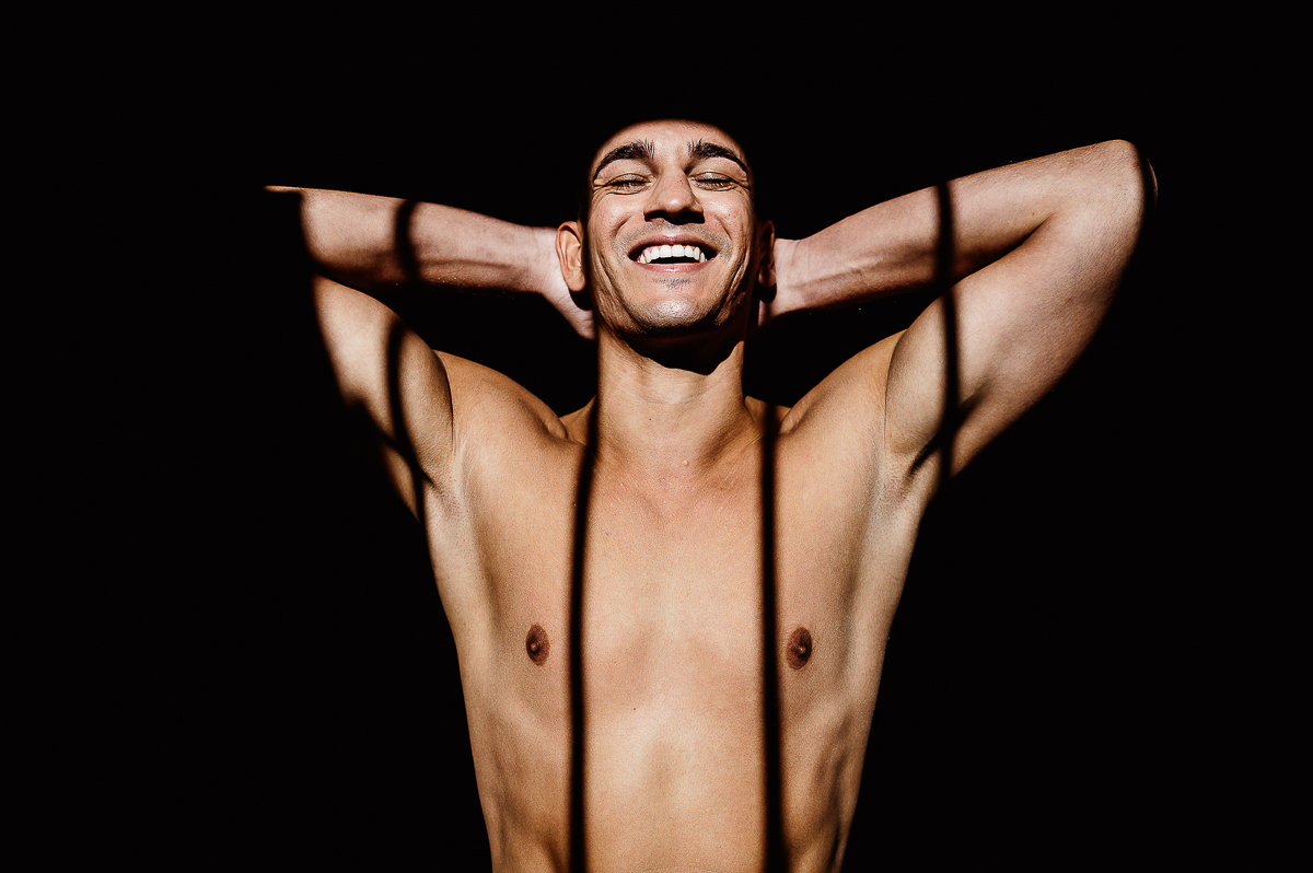 matrimonio a Chieri, preparazione dello sposo, sposo a torso nudo con una bellissima luce che proviene dalla finestra