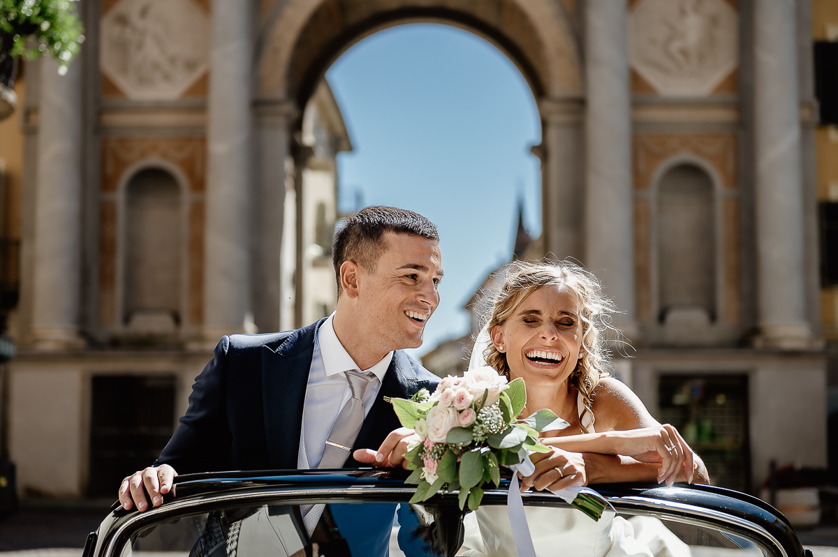 matrimonio a Chieri .Foto di coppia all'Arco Monumentale di Chieri. Sposi nell'auto scoperta maggiolino bianco d'epoca.