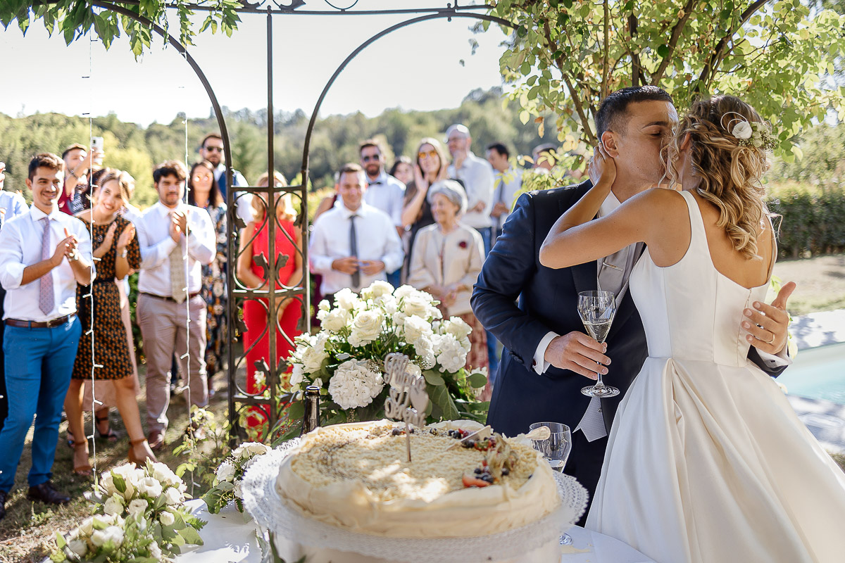 matrimonio al ristorante albergo Ca' Vittoria di Tigliole d'Asti.Taglio della torta.Sposi che si baciano. Invitati che guardano e applaudono
