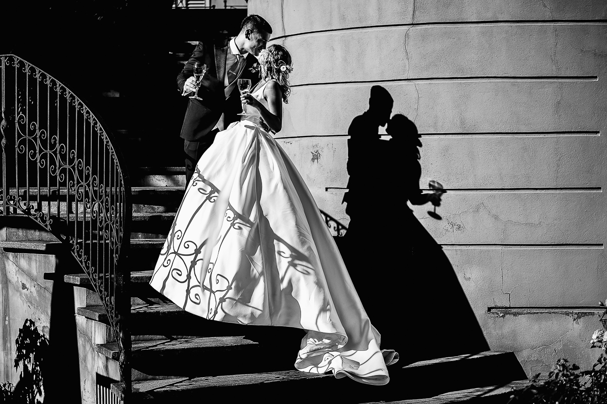 matrimonio al ristorante albergo Ca' Vittoria di Tigliole d'Asti.Sposi che si abbracciano sulle scale. Ombra riflessa sulla parete.Bianco e nero