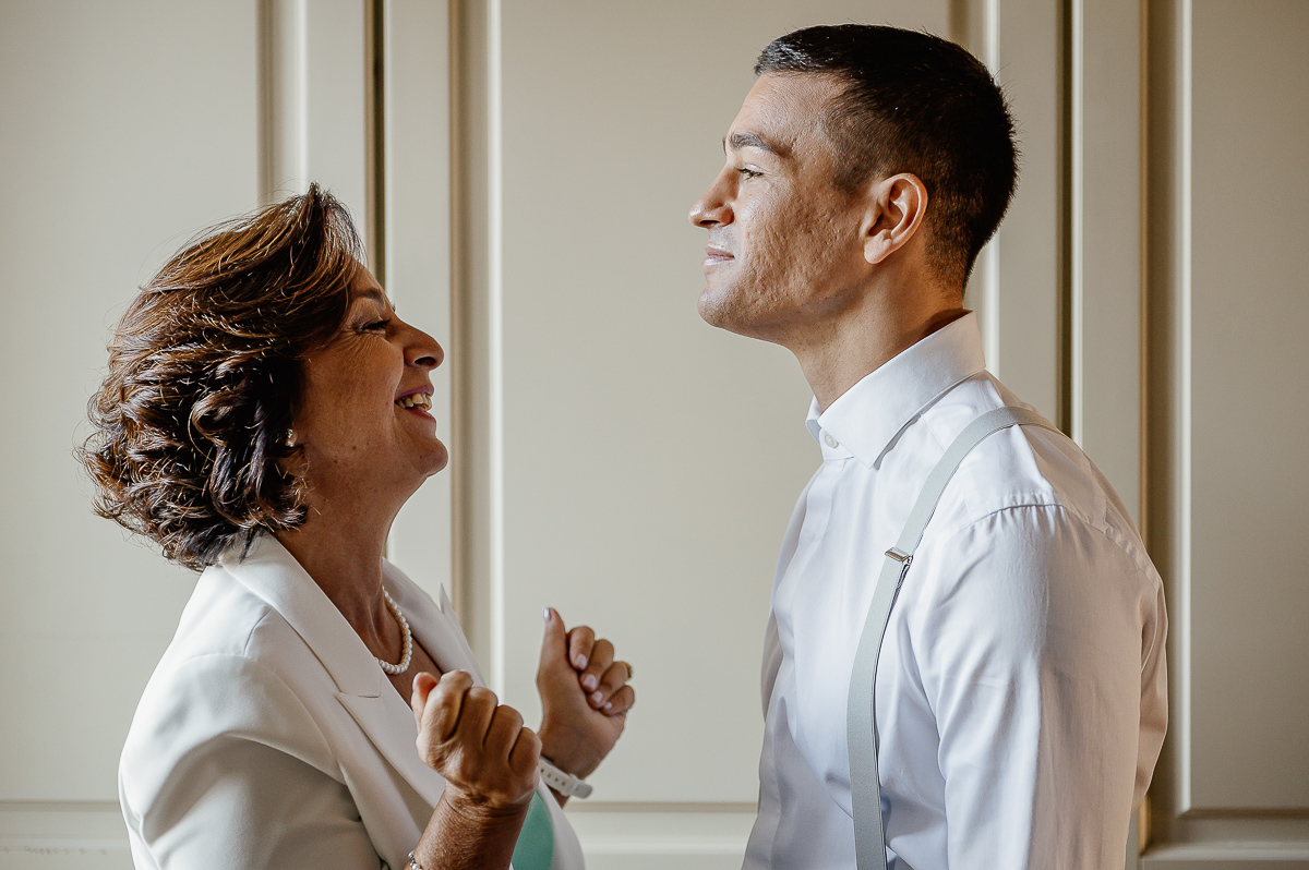 matrimonio a Chieri, preparazione dello sposo, mamma che guarda lo sposo con orgoglio