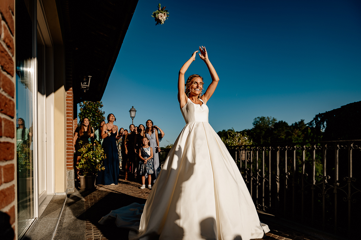 matrimonio al ristorante albergo Ca' Vittoria di Tigliole d'Asti.Lancio del bouquet. Bouquet in volo nel cielo azzurro