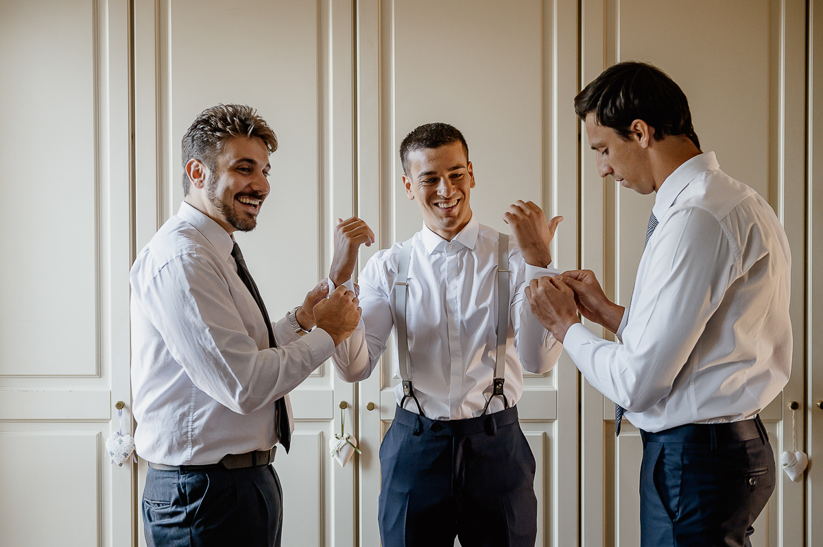 matrimonio a Chieri, preparazione dello sposo, testimoni che sistemano i gemelli della camicia allo sposo