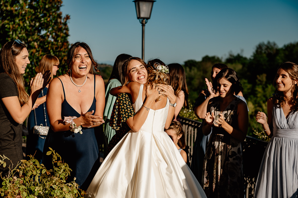 matrimonio al ristorante albergo Ca' Vittoria di Tigliole d'Asti.Lancio del Bouquet. Sposa che abbraccia la ragazza che ha preso il bouquet