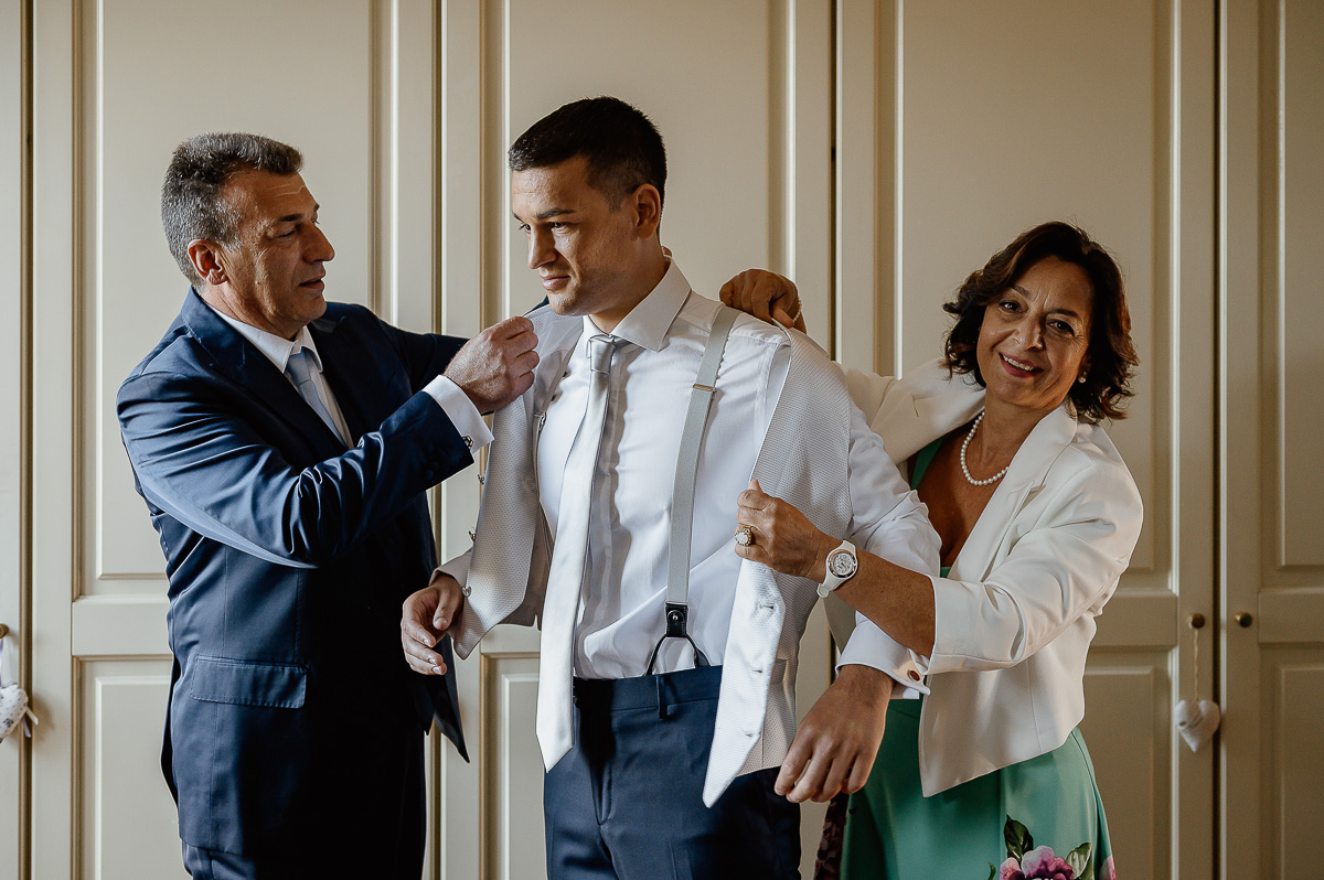 matrimonio a Chieri, preparazione dello sposo,papà e mamma che aiutano lo sposo nella vestizione