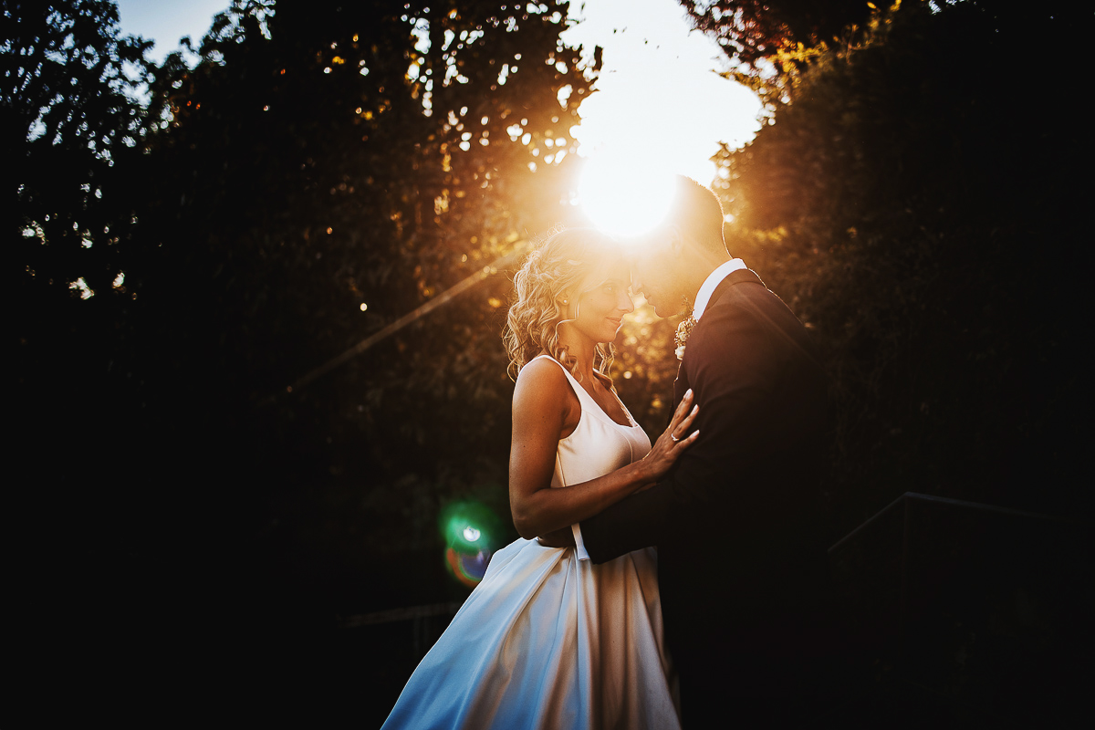 matrimonio al ristorante albergo Ca' Vittoria di Tigliole d'Asti.Foto di coppia.Sposi al tramonto con sole che forma un flare fra di loro