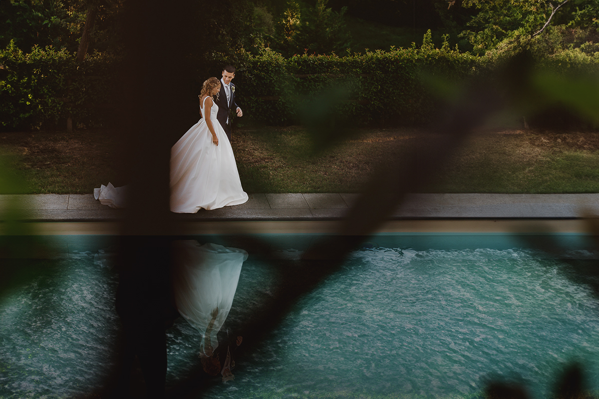 matrimonio al ristorante albergo Ca' Vittoria di Tigliole d'Asti.Foto di coppia.Sposi che camminano riflessi nella piscina