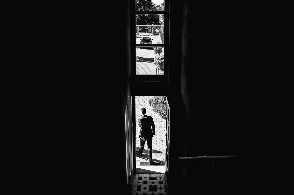 matrimonio a Chieri, preparazione dello sposo, sposo che esce di casa, silhouette in controluce, bianco e nero