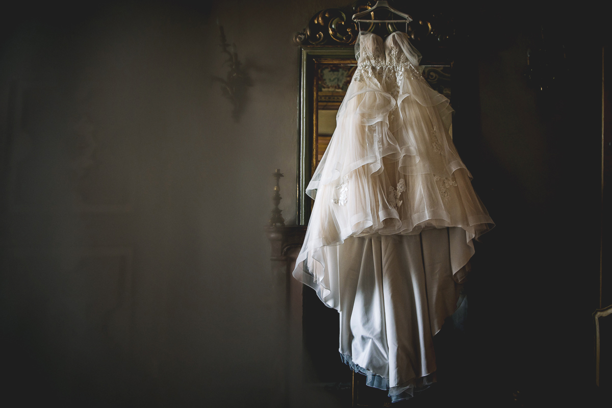 Matrimonio al Castello Canalis di Cumiana(TO). Preparazione della sposa. Abito appeso allo specchio del camino
