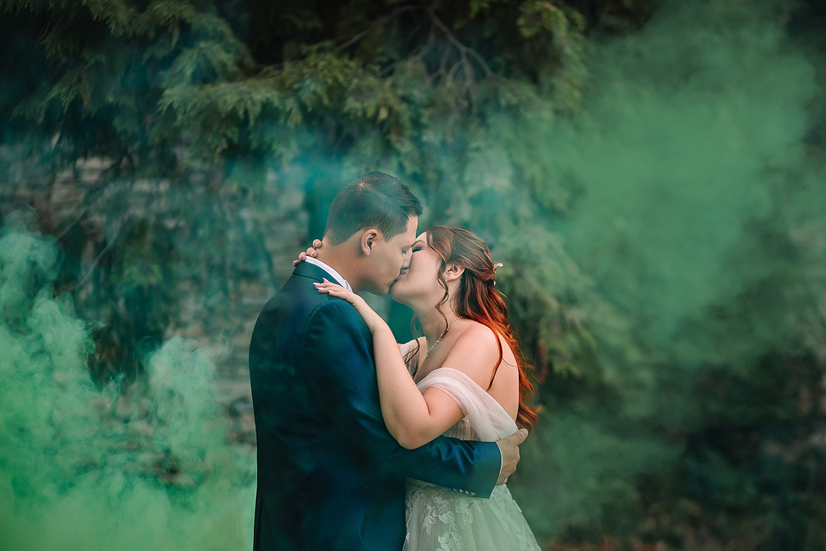Matrimonio al Castello Canalis di Cumiana(TO). Servizio di coppia Sposi che si baciano tra i fumogeni verdi che creano una magica atmosfera