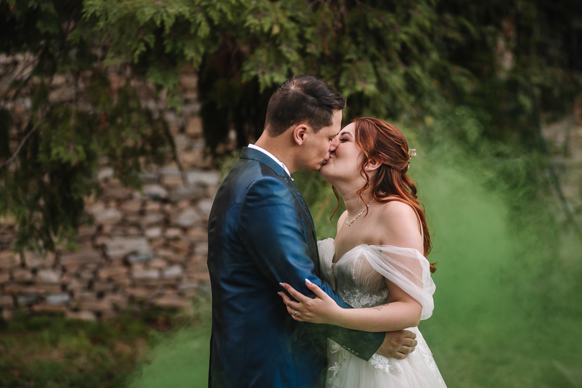 Matrimonio al Castello Canalis di Cumiana(TO). Servizio di coppia Sposi che si baciano tra i fumogeni verdi che creano una magica atmosfera