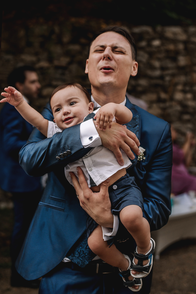 Matrimonio al Castello Canalis di Cumiana(TO). Aperitivo. Sposo che tiene in braccio un bambino.