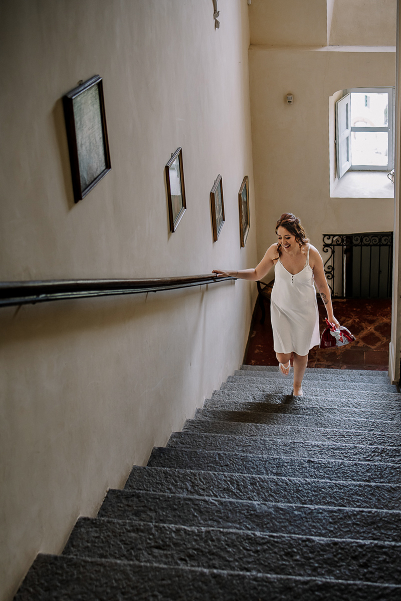 Matrimonio al Castello Canalis di Cumiana(TO).Sposa che sale lo scalone ancora in sottoveste