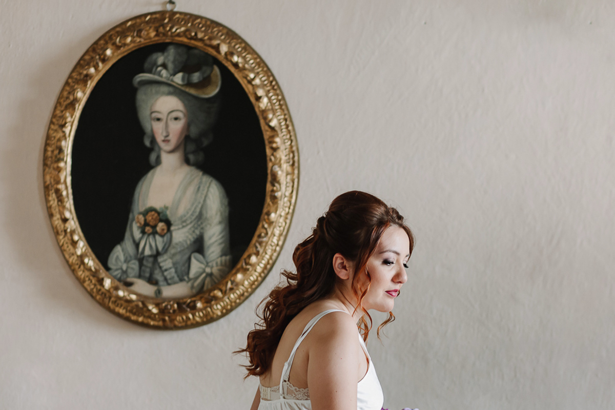 Matrimonio al Castello Canalis di Cumiana(TO). Sposa davanti ad un dipinto settecentesco ovale che raffigura una dama dell'epoca.