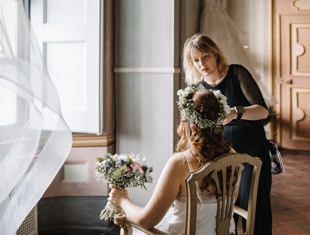 Matrimonio al Castello Canalis di Cumiana(TO). Sposa dubbiosa sulla coroncina di fiori freschi che la parrucchiera le ha posto sul capo