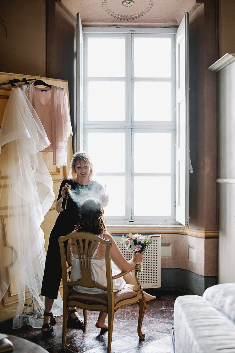 Matrimonio al Castello Canalis di Cumiana(TO). Parruchiera che spruzza la lacca sui capelli della sposa.