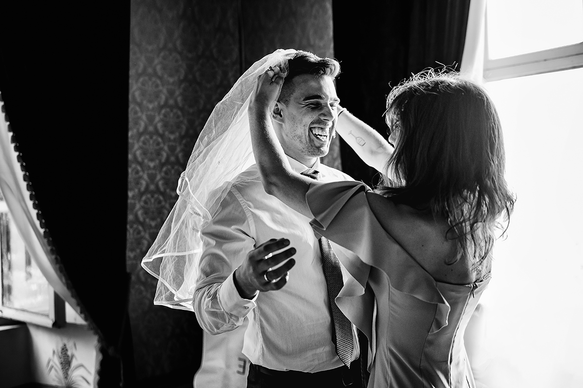 Matrimonio al Castello Canalis di Cumiana(TO). Testimone della sposa che mette un velo da sposa per scherzo sul capo di un altro testimone.