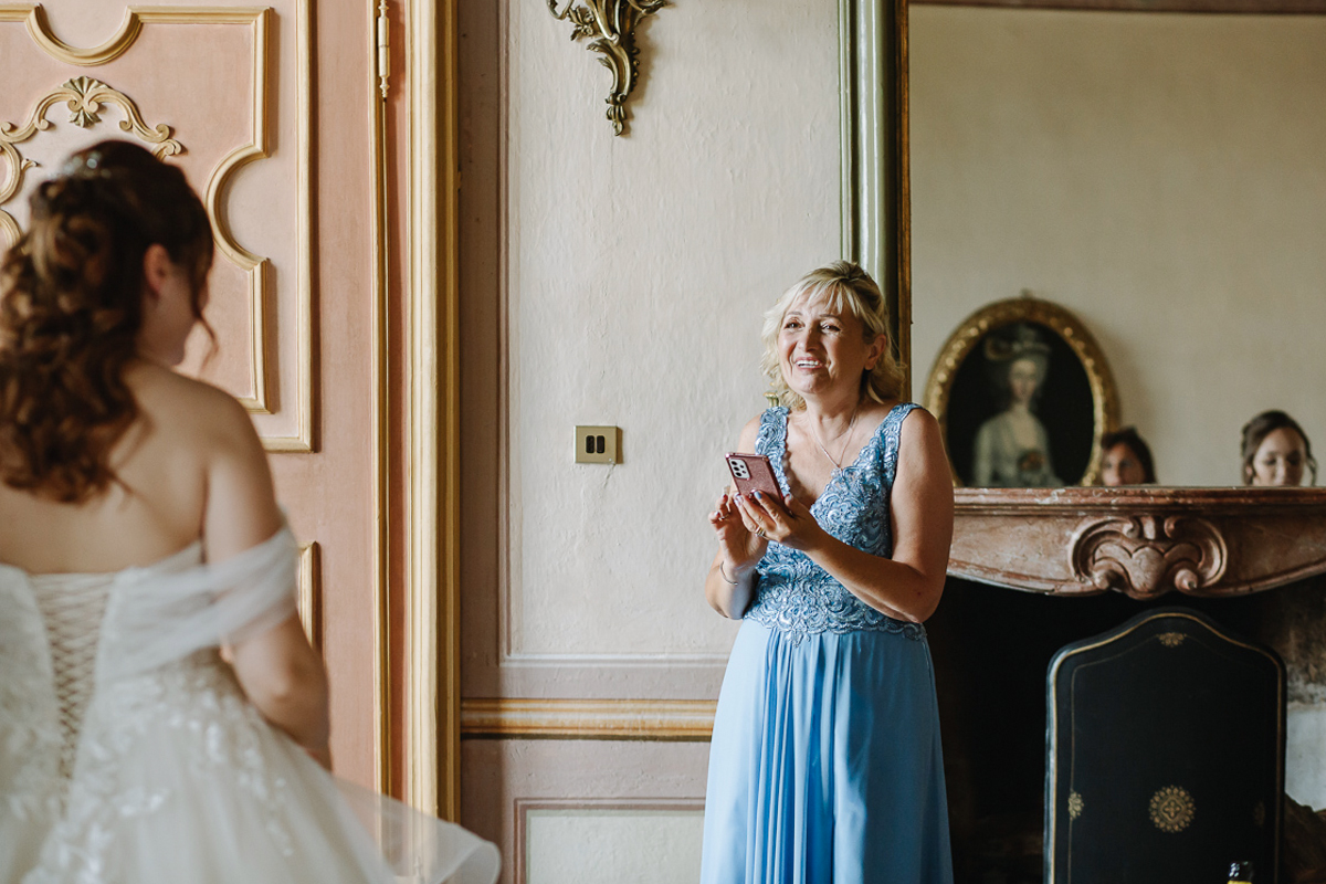Matrimonio al Castello Canalis di Cumiana(TO). mamma che fotografa la sposa con il suo bell'abito.