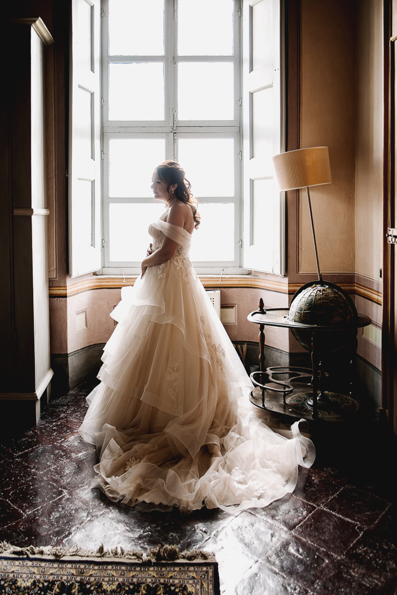 Matrimonio al Castello Canalis di Cumiana(TO). Ritratto della sposa alla finestra
