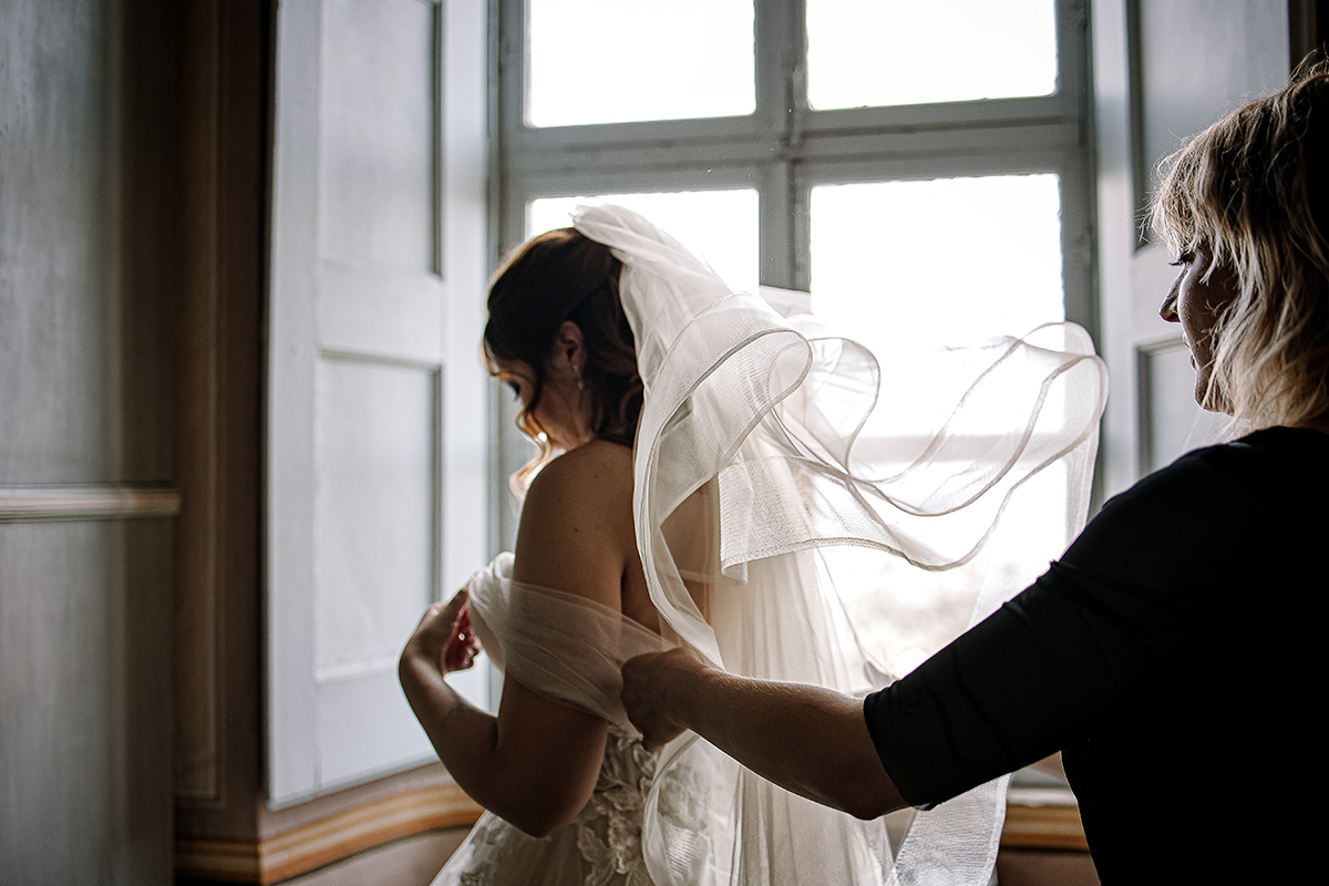 Matrimonio al Castello Canalis di Cumiana(TO). Parrucchiera che sistema il velo della sposa.