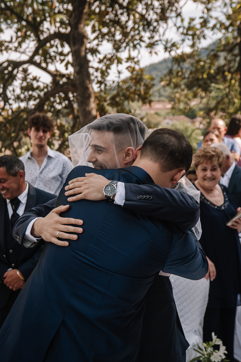 Matrimonio al Castello Canalis di Cumiana(TO). Cerimonia. Sposo che abbraccia l'amico con il velo