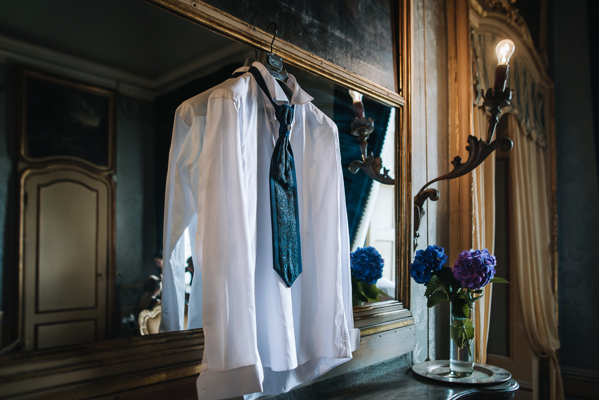 Matrimonio al Castello Canalis di Cumiana(TO). Preparazione dello sposo. Camicia e cravatta appesi allo specchio sul camino.