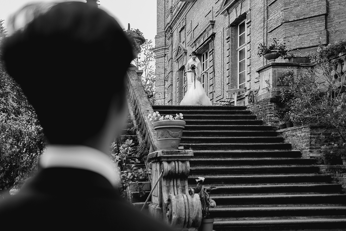 Castello di Collegno, matrimonio cinese. Cerimonia occidentale. Sposo attende la sposa che scende dallo scalone esterno del castello.