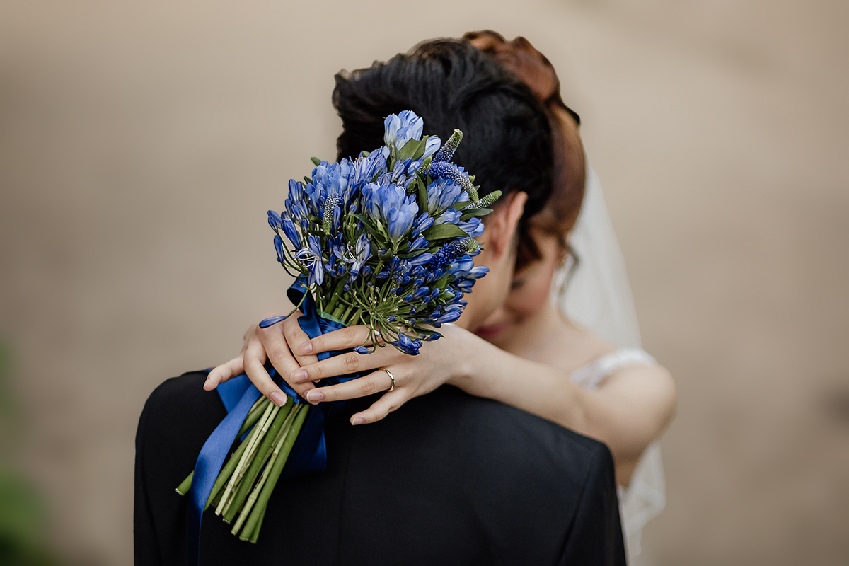 Castello di Collegno, matrimonio cinese. Cerimonia occidentale. Fotografia di coppia. ritratto degli sposi uno di fronte all'altra. Dettaglio del bouquet blu Cina.