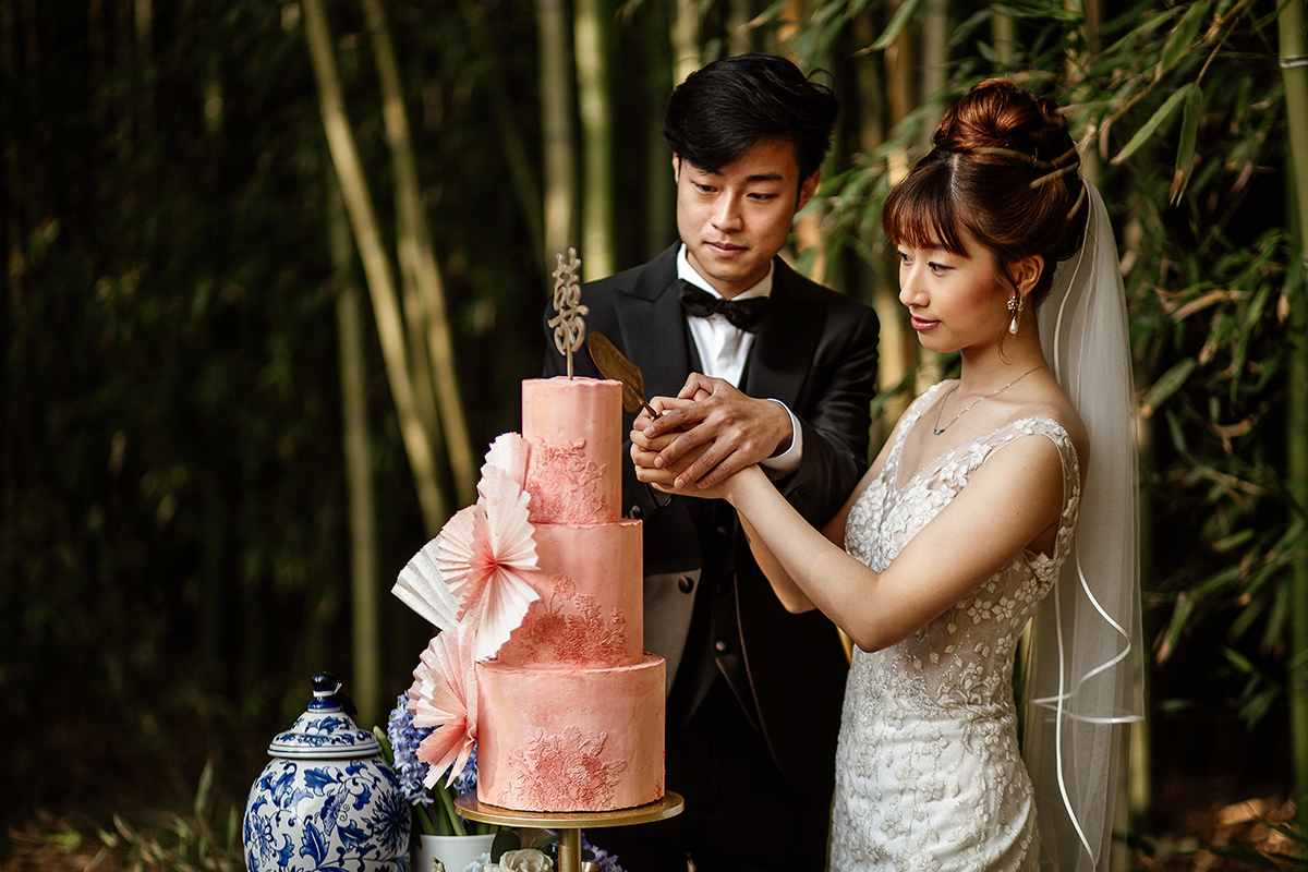 Castello di Collegno, matrimonio cinese. Cerimonia occidentale. Taglio della torta. Allestimento con oggettistica cinese di ceramica con decori blu Cina. Sposi tagliano la torta.