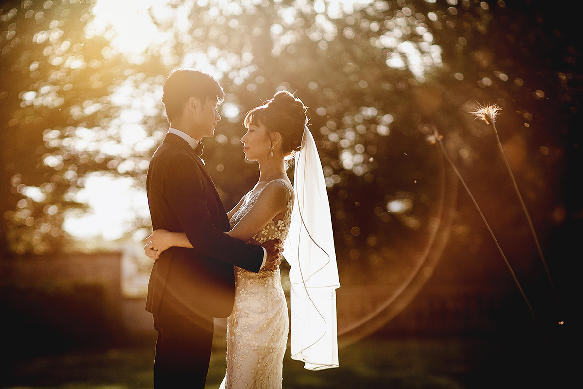 Castello di Collegno, matrimonio cinese. Cerimonia occidentale. Fotografia degli sposi al tramonto. Flare con ring of fire