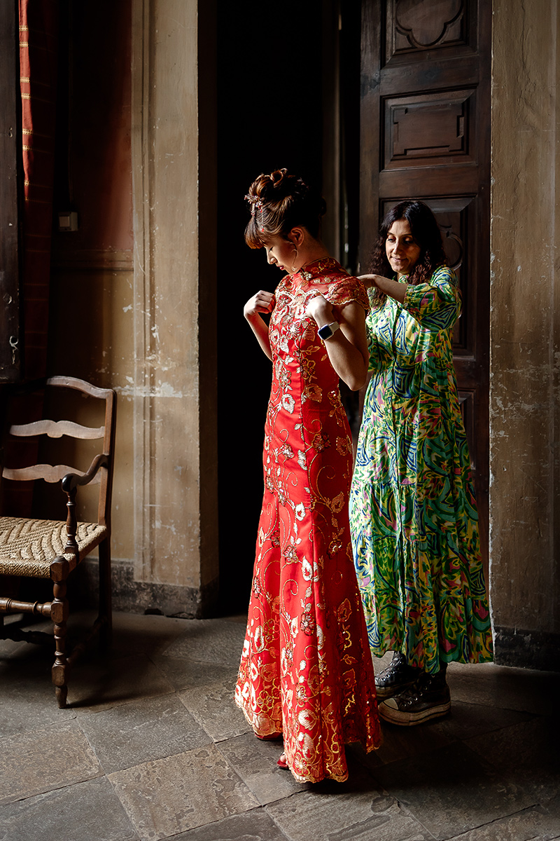 Castello di Collegno, matrimonio cinese. Cerimonia tradizionale. Preparazione della sposa. Wedding planner veste la sposa.