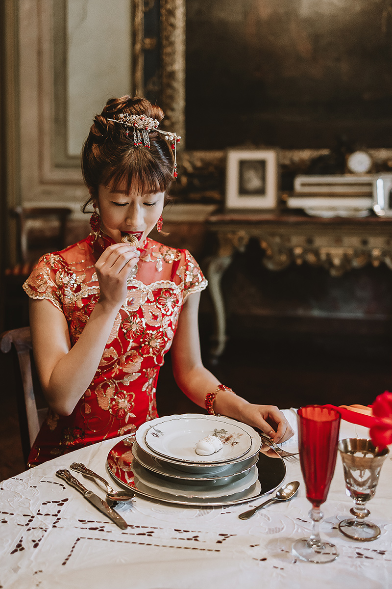 Castello di Collegno, matrimonio cinese. Cerimonia tradizionale. Pranzo. tavola apparecchiata nel salone delle feste del castello. Sposa mangia.
