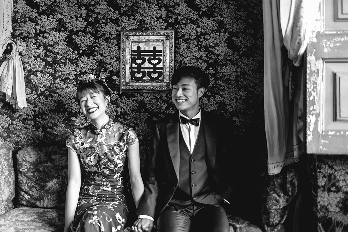 Castello di Collegno, matrimonio cinese. Cerimonia tradizionale nel salottino cinese del castello. Ritratto degli sposi seduti al divano sotto il simbolo della doppia felicità, tradizionale cinese 囍