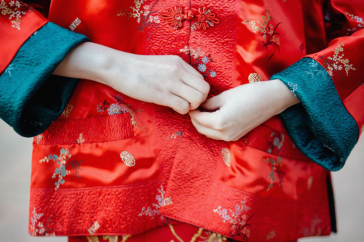 Castello di Collegno, matrimonio cinese. Cerimonia tradizionale. Sessione fotografica di coppia. sposa indossa una giacca tradizionale cinese di seta rossa ricamata.
