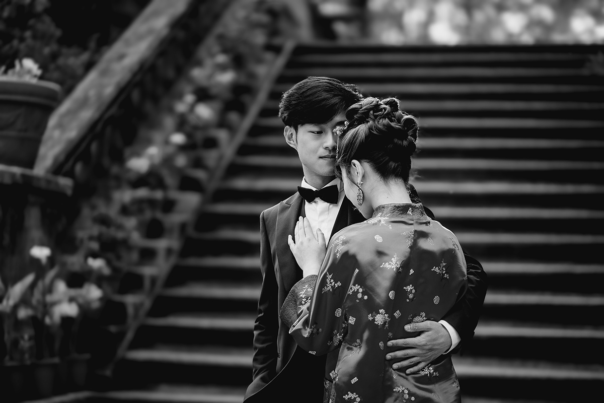 Castello di Collegno, matrimonio cinese. Cerimonia tradizionale. Sessione fotografica di coppia. sposa indossa una giacca tradizionale cinese di seta rossa ricamata. Ritratto intimo degli sposi. Bianco e nero.