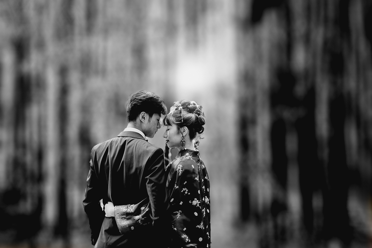 Castello di Collegno, matrimonio cinese. Cerimonia tradizionale. Sessione fotografica di coppia. sposa indossa una giacca tradizionale cinese di seta rossa ricamata. Ritratto intimo degli sposi. nel bosco dei bambù, bianco e nero.
