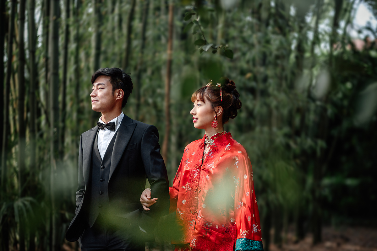 Castello di Collegno, matrimonio cinese. Cerimonia tradizionale. Sessione fotografica di coppia. sposa indossa una giacca tradizionale cinese di seta rossa ricamata.Sposi camminano nel bosco dei bambù