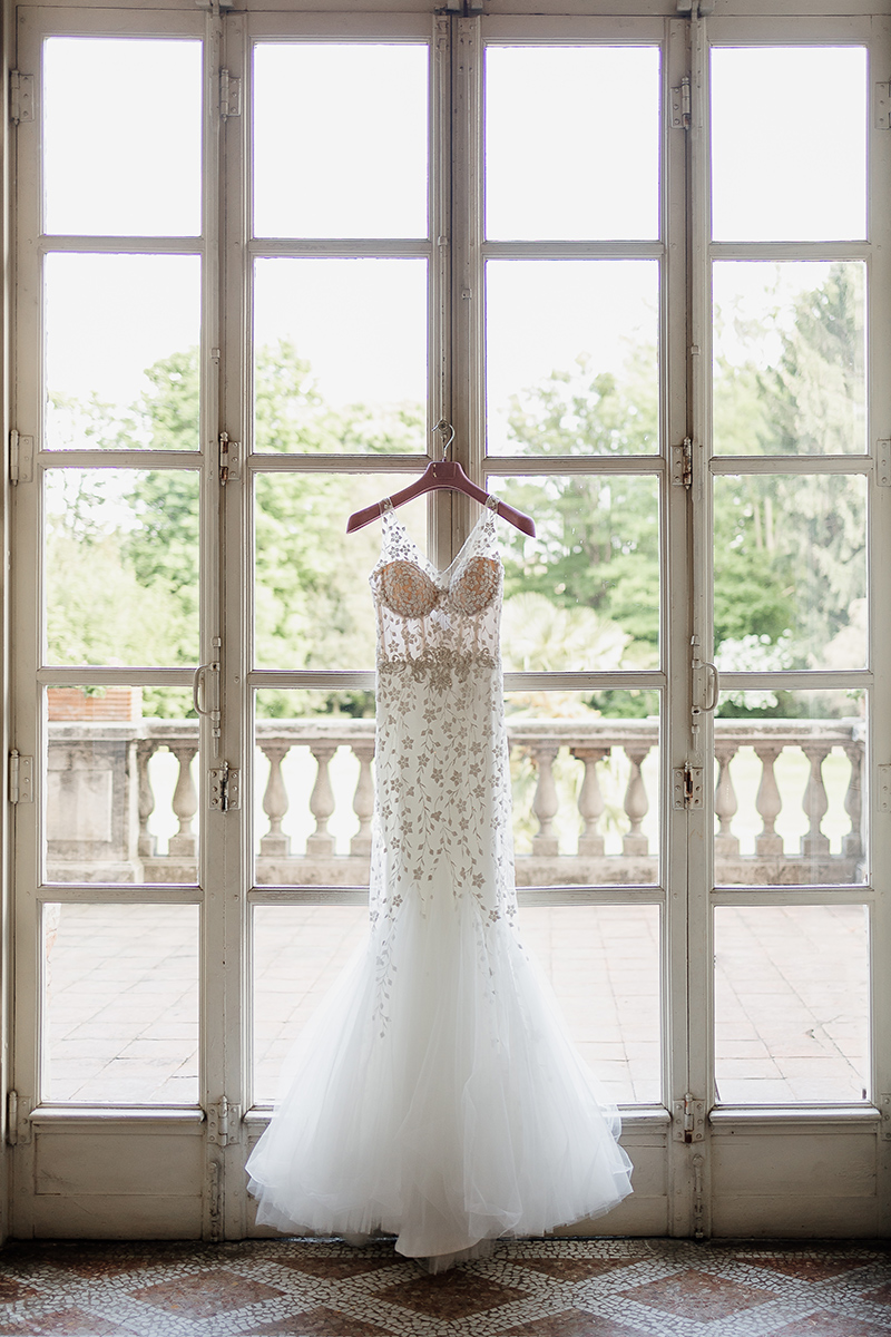 Castello di Collegno, matrimonio cinese. Cerimonia occidentale. Abito da sposa bianco appeso alla vetrata.