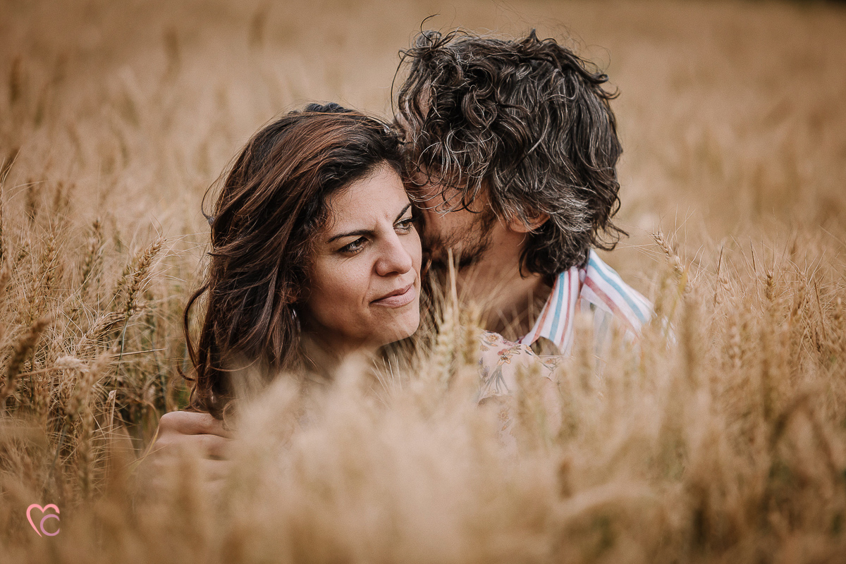 Fotografia di coppia in collina a Chieri. Daniela e Gianluca seduti nel campo di grano.