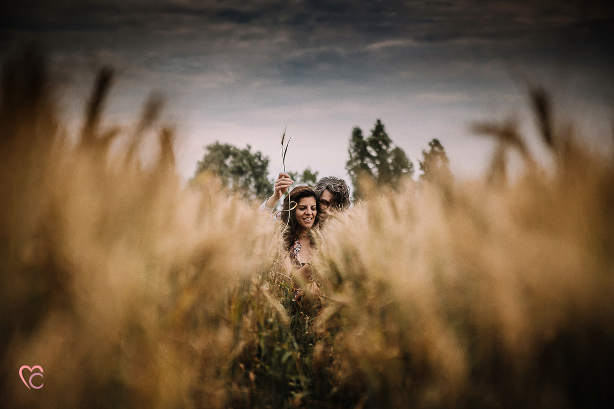 Fotografia di coppia in collina a Chieri. Daniela e Gianluca seduti nel campo di grano.