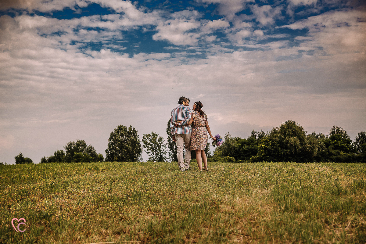 Fotografia di coppia in collina a Chieri. Daniela e Gianluca camminano tenendosi per la vita.