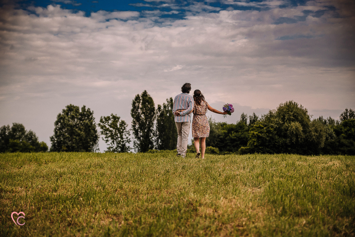 Fotografia di coppia in collina a Chieri. Daniela e Gianluca camminano tenendosi per la vita