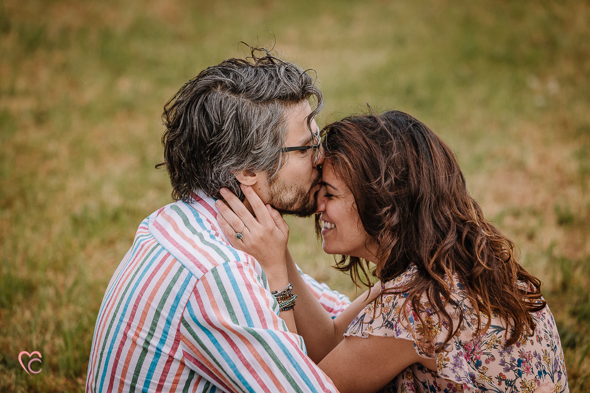 Fotografia di coppia in collina a Chieri. Daniela e Gianluca seduti nel prato, fronte fronte