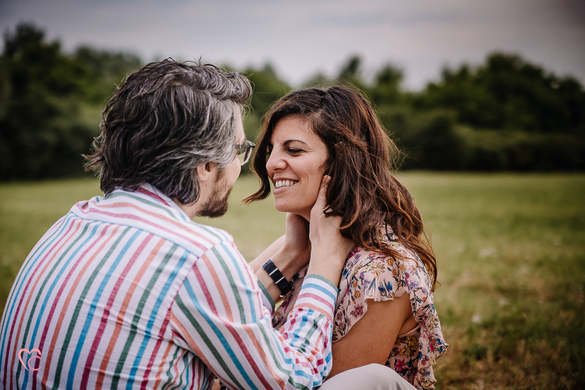 Fotografia di coppia in collina a Chieri. Daniela e Gianluca seduti nel prato,