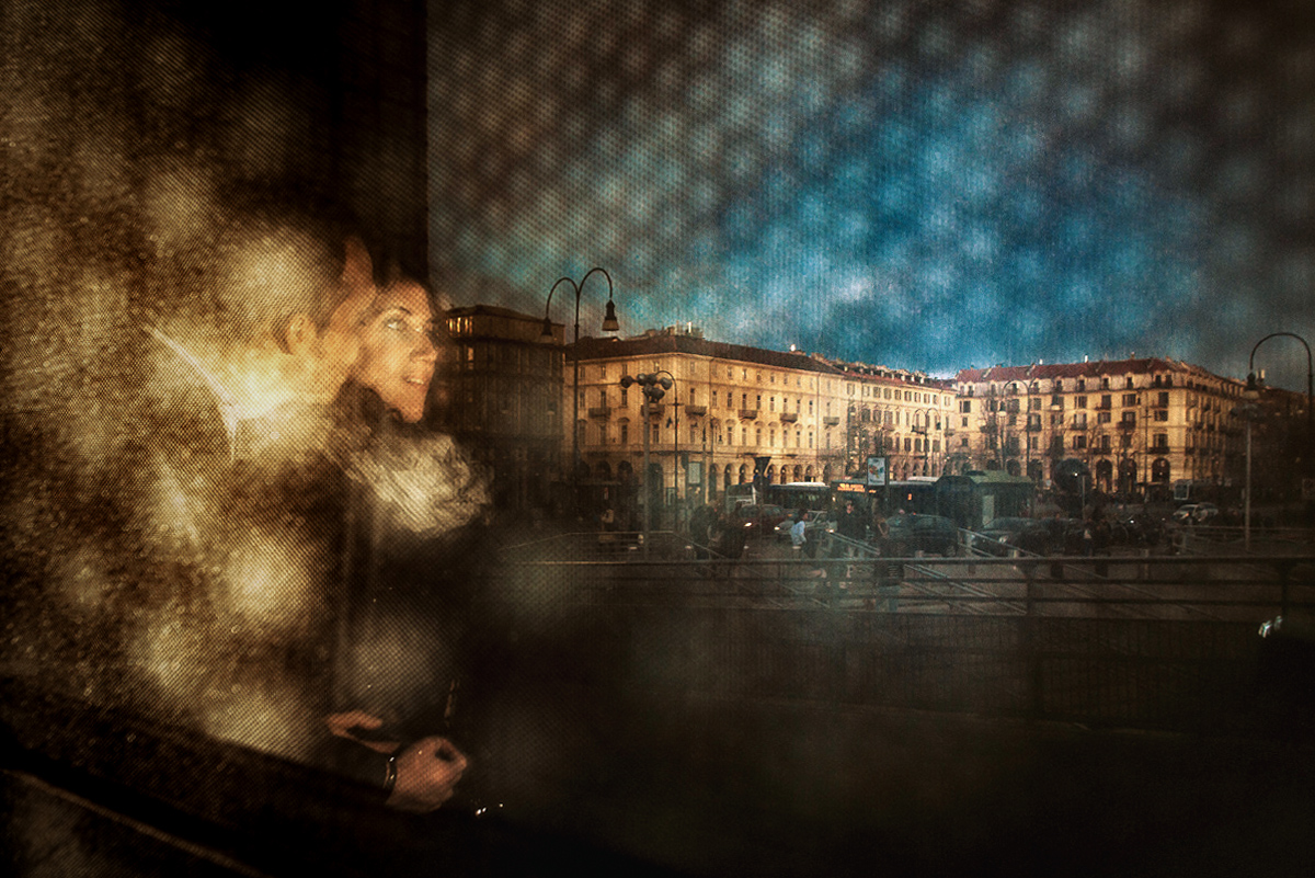 Engagement a Torino nella stazione di Porta Susa. Ritratto degli sposi e di piazza XX febbraio attraverso una grata d'acciao