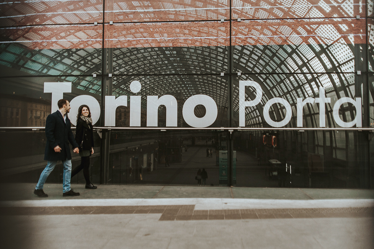 Engagement a Torino nella stazione di Porta Susa. La coppia cammina davanti all'entrata della stazione.