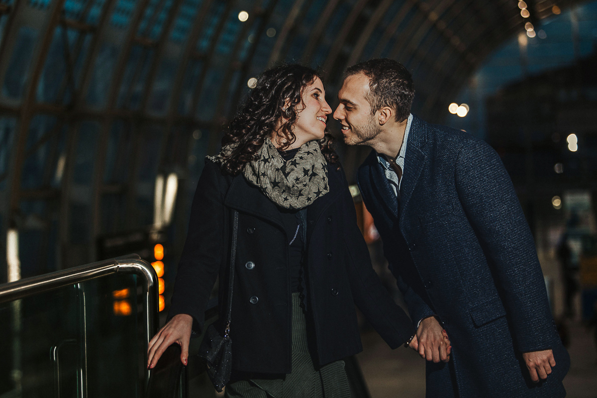 Engagement a Torino nella stazione di Porta Susa. Coppia ll'interno della stazione sulla scala mobile
