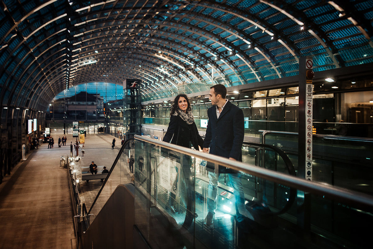 Engagement a Torino nella stazione di Porta Susa. Coppia ll'interno della stazione sulla scala mobile