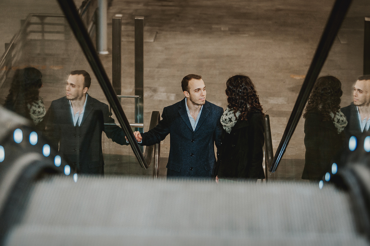 Engagement a Torino nella stazione di Porta Susa. Coppia ll'interno della stazione sulla scala mobile