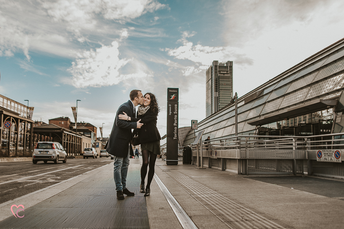Engagement a Torino nella stazione di Porta Susa. La coppia si tiene per mano fuori dalla stazione baciandosi
